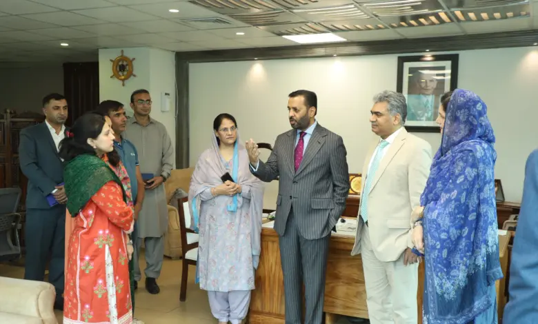 DHO Islamabad officials presenting annual journal book to Federal Health Minister Syed Mustafa Kamal