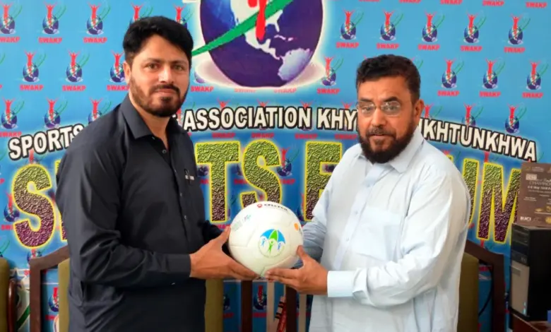 Asim Sheraz receiving a football from Absar Welfare Foundation Chairman Rahat Mian
