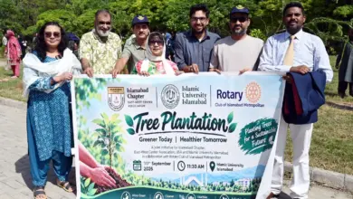 Participants plant trees during EWCA Islamabad Chapter plantation drive at IIUI