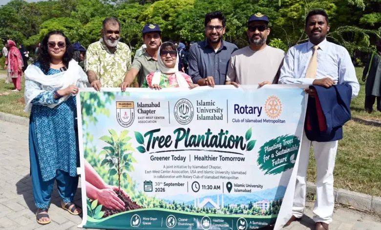 Participants plant trees during EWCA Islamabad Chapter plantation drive at IIUI